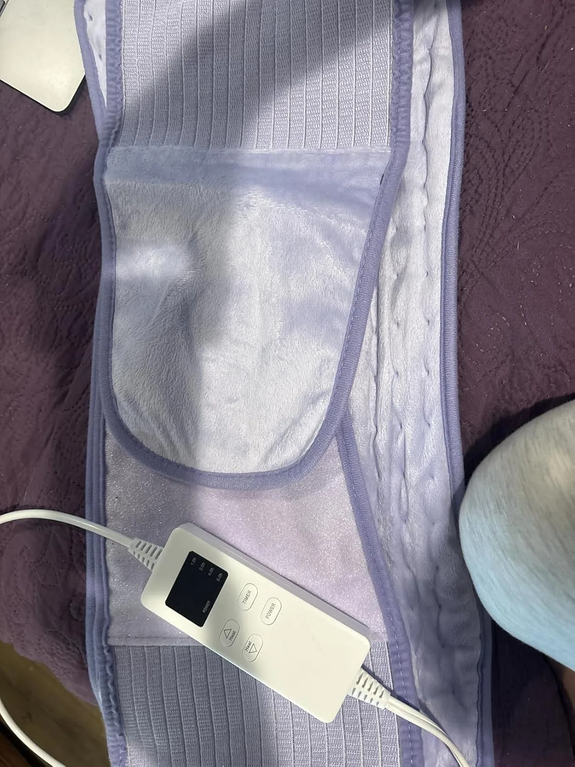 Customer photo showing heating pad applied to lower abdomen for IBS relief