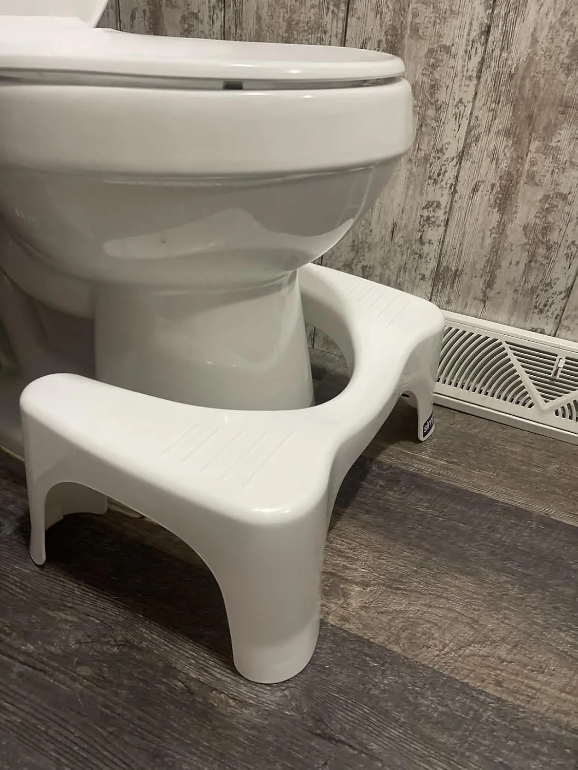 Customer photo of white squatting toilet stool positioned in front of bathroom toilet