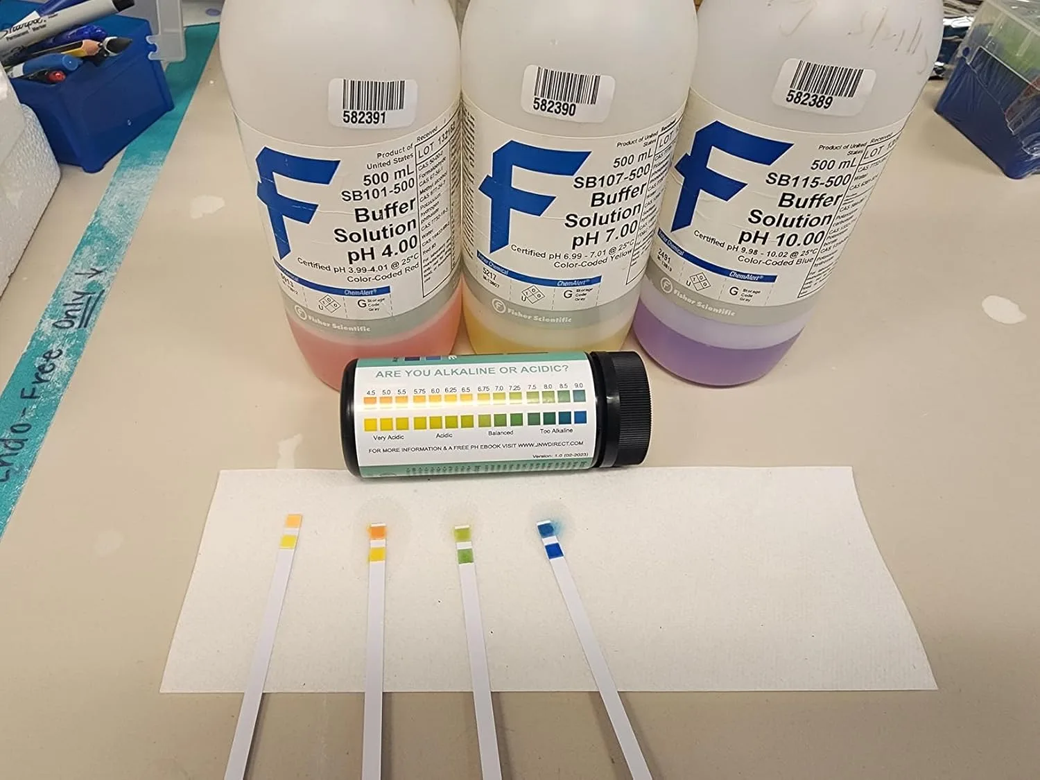 Customer photo of pH test strips being used to measure acidity levels in saliva sample